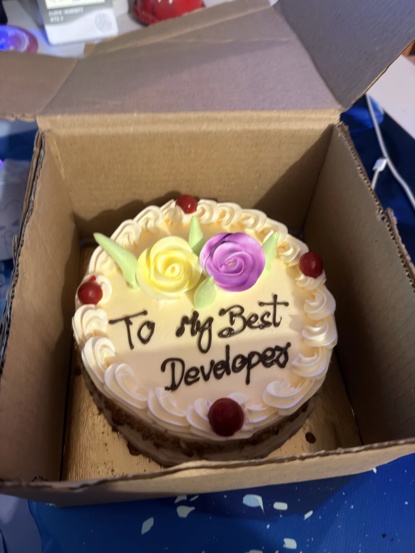 A cream cake with icing flowers and the message To My Best Developer