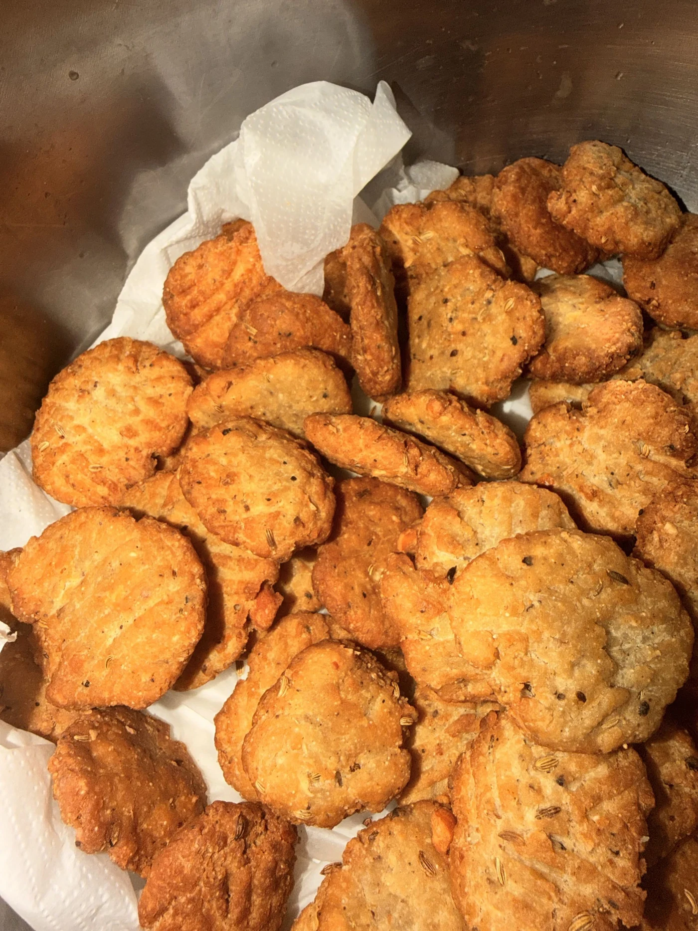 Golden round biscuits arranged in a metal container