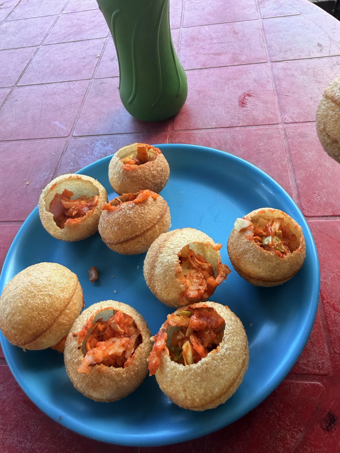 Crisp filled puri shells on a bright blue plate