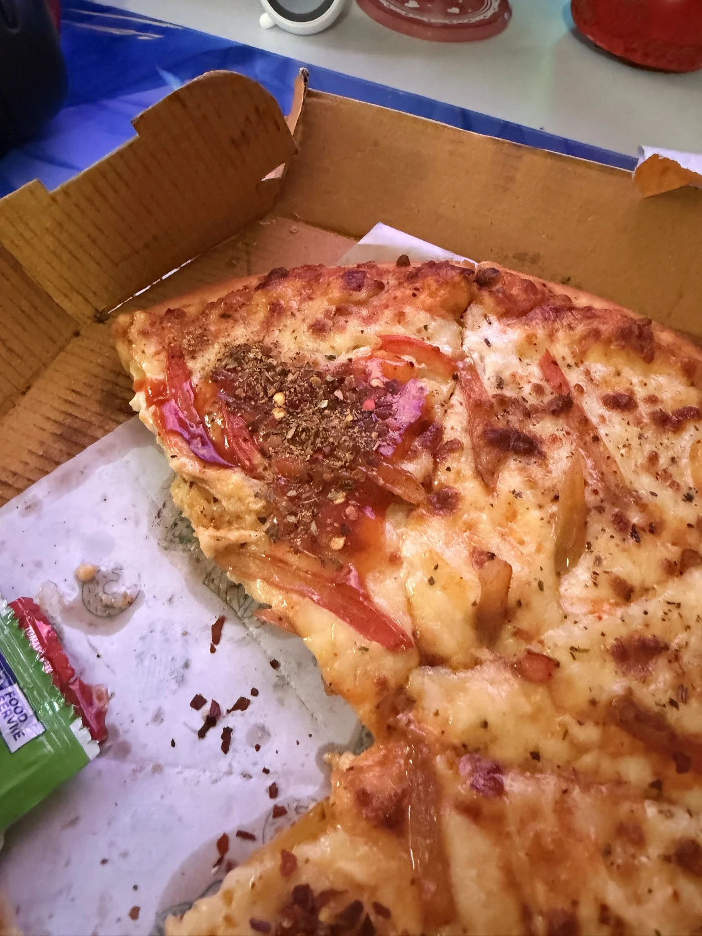 A close view of pizza sprinkled with herbs and chilli flakes