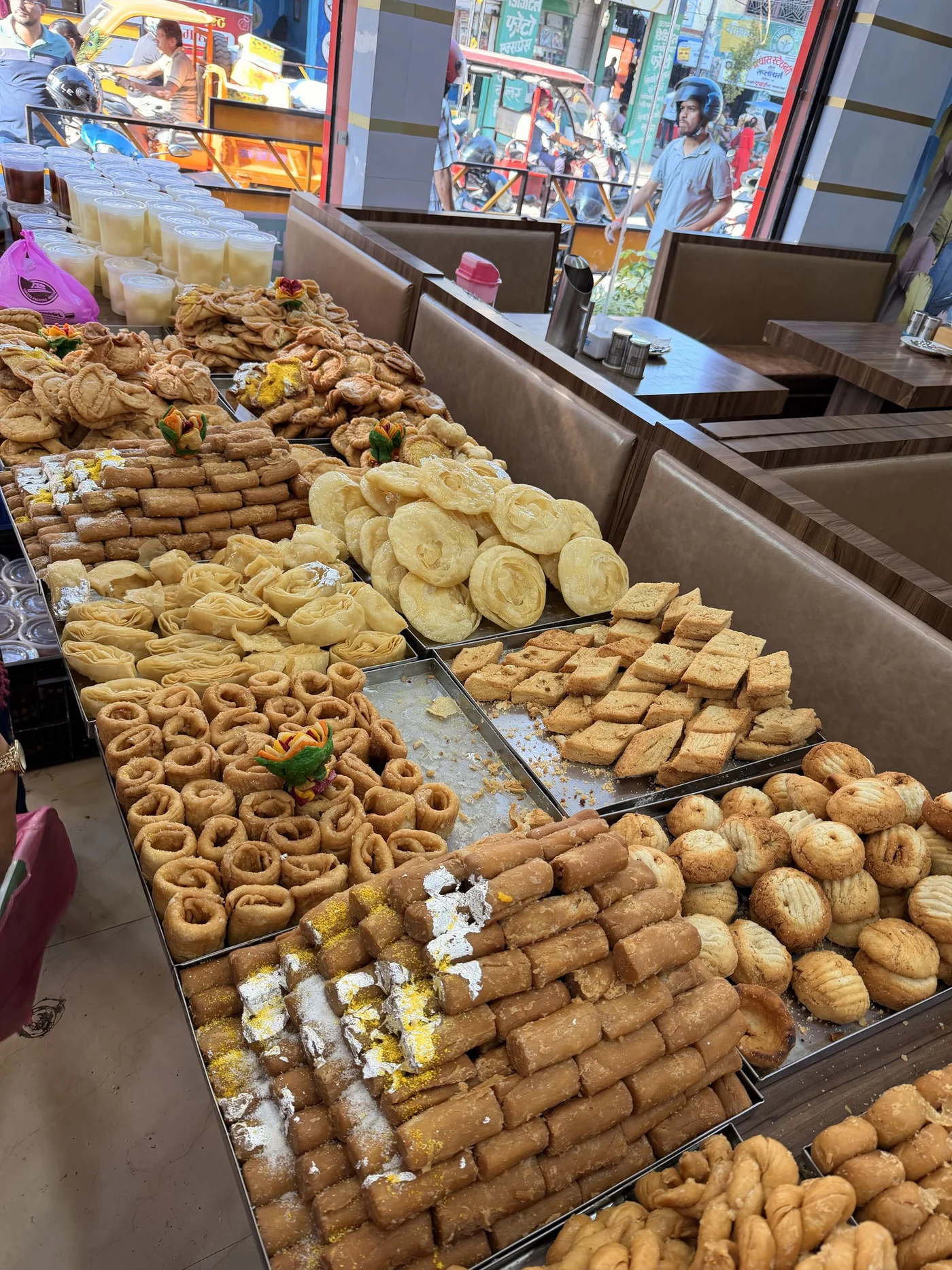 Rows of pastries and sweets beside the open front of a shop